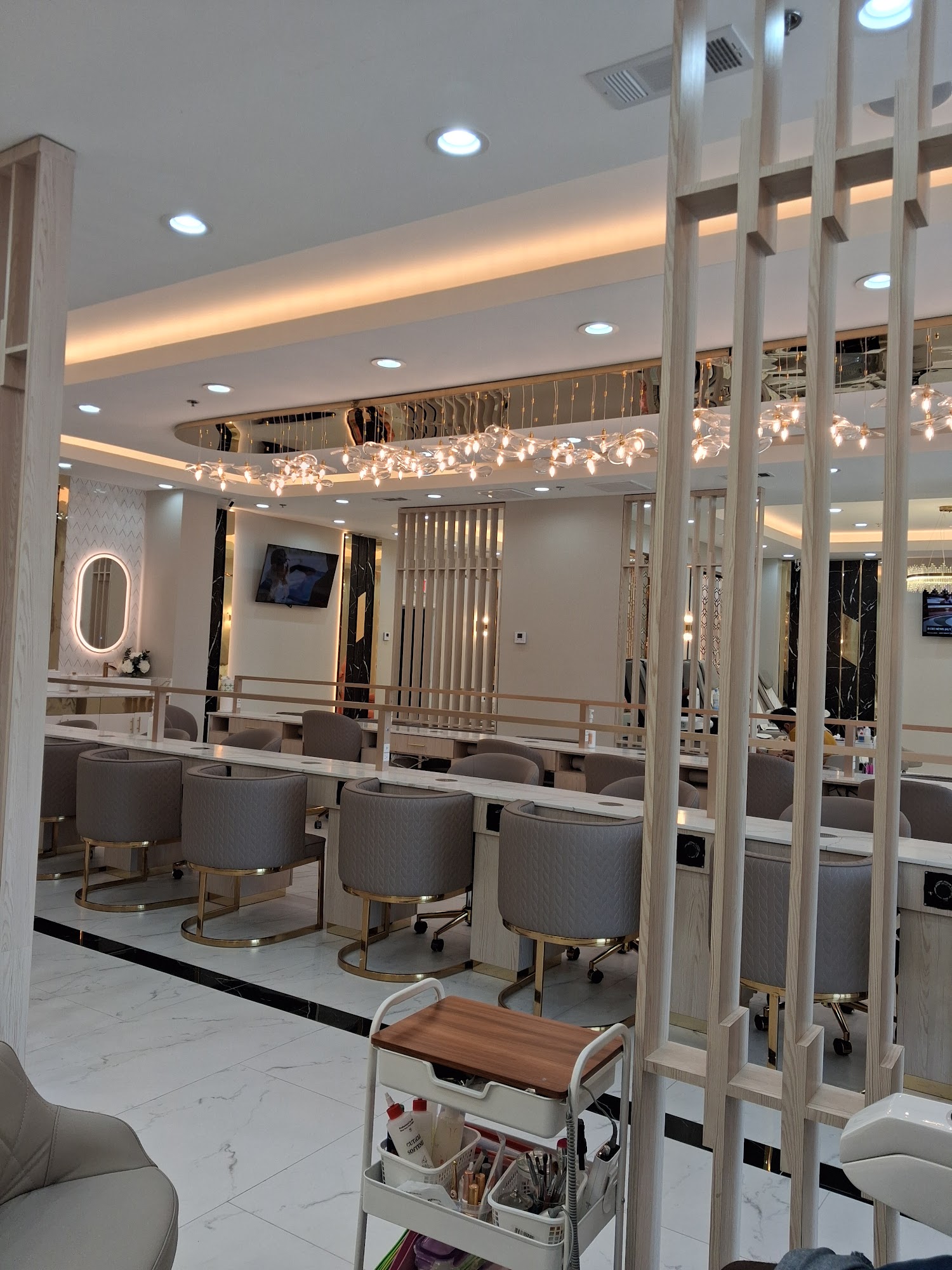 Manicure bar with gold-framed chairs and marble counters